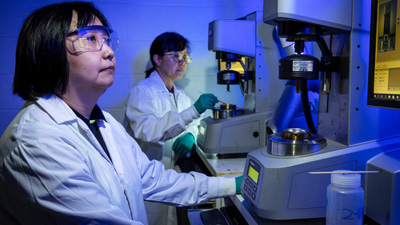 TOUGH TEST: Boeing engineer Jacquelynn Tian, left, and Boeing chemist Ha Le prepare resin for product acceptance testing to verify the material meets Boeing’s specification requirements.