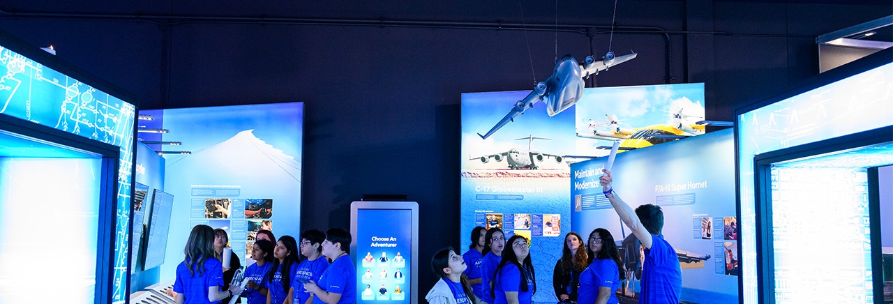  Group of young people being shown models and images of airplanes