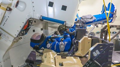 Wearing her Boeing blue spacesuit and red polka-dot head scarf, teams strapped the anthropometric test device securely into the commander seat.